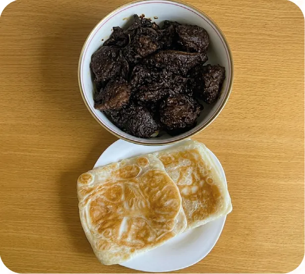 Beef kala bhuna in a bowl with two paratha